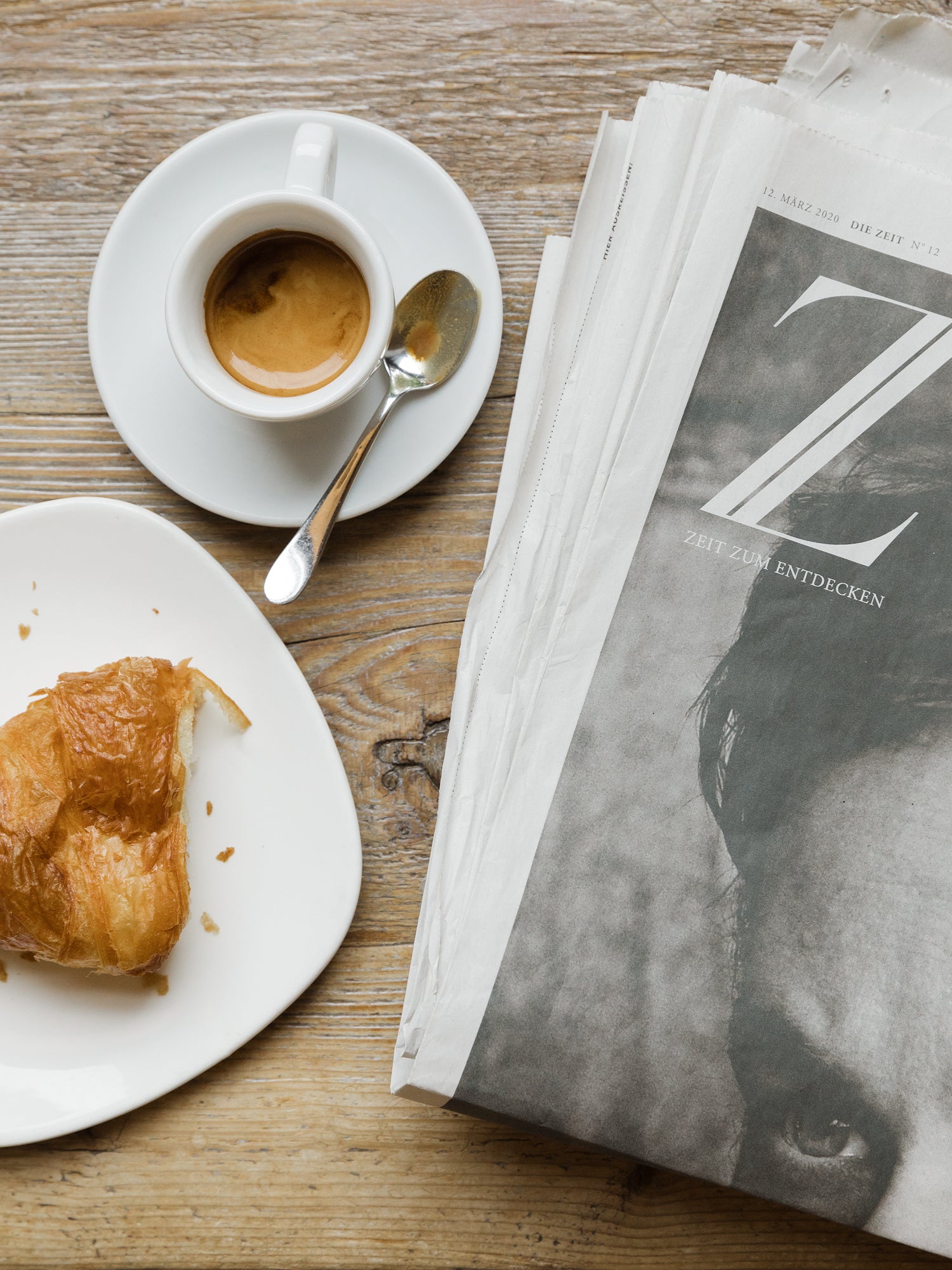 Cafetisch mit Croissant und Zeitung